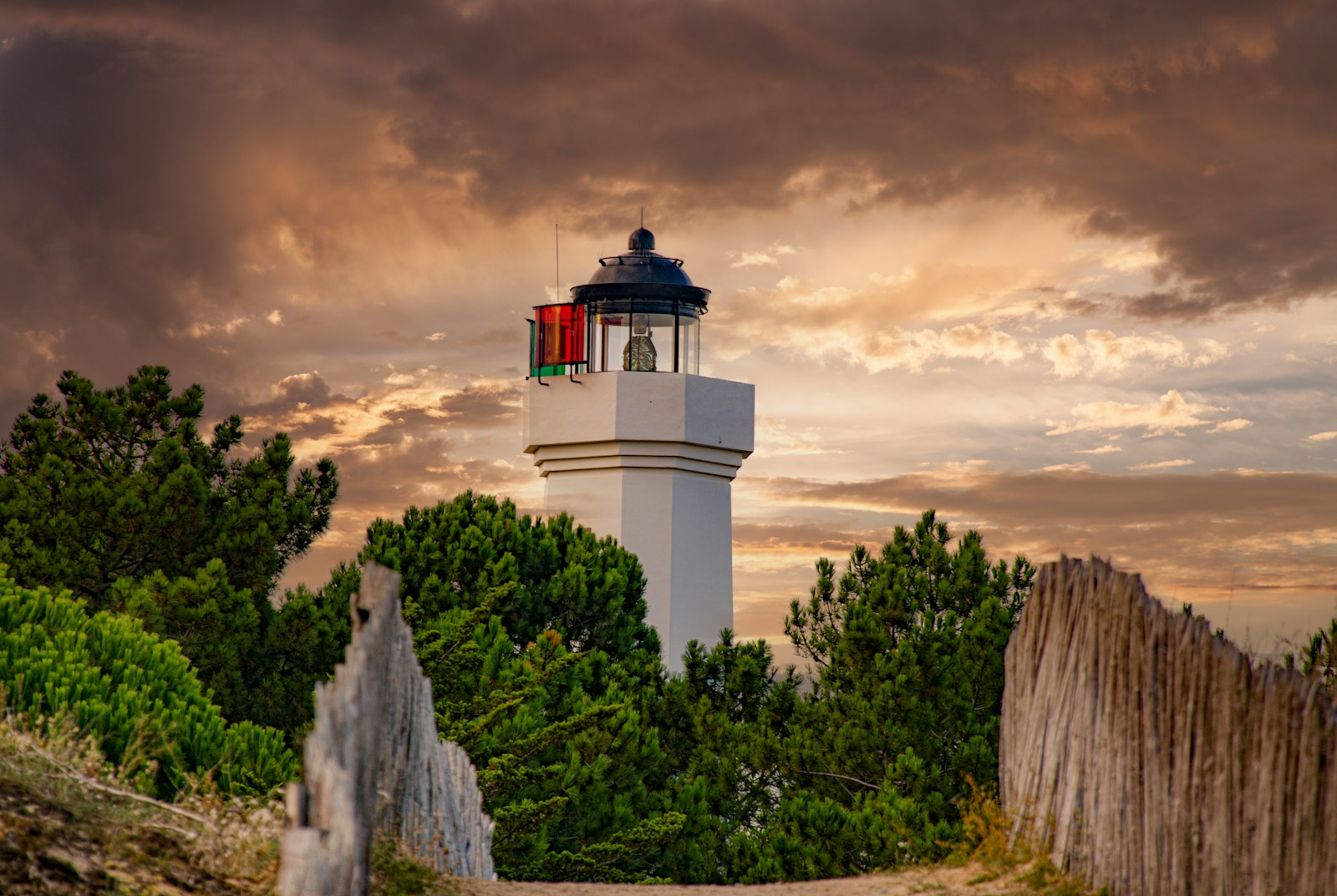 a white lighthouse with a red light on top of it