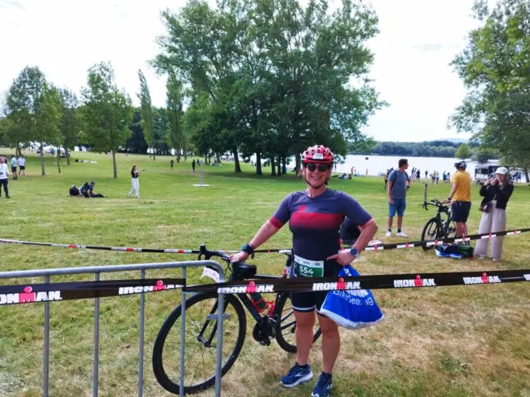 Bénévole de l'association qui se tient à côté de son vélo.